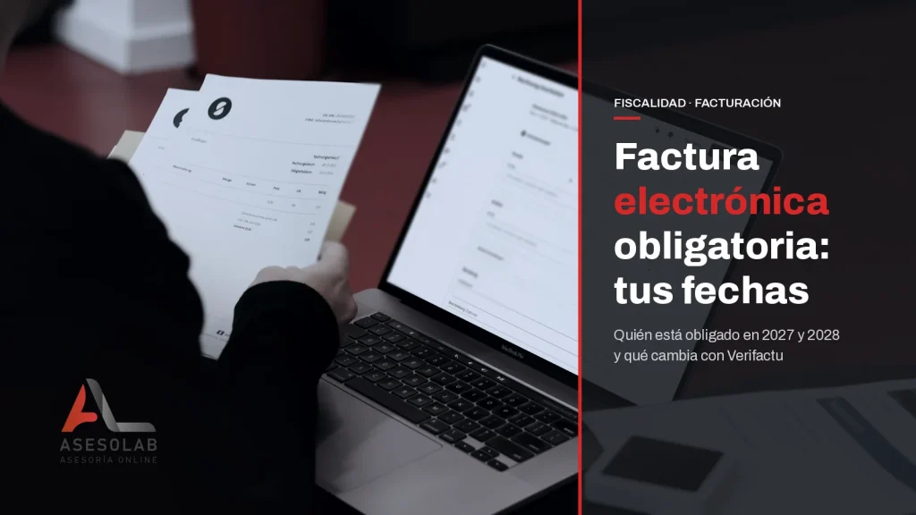 Empresario revisa facturas en papel junto al portátil, con el titular sobre las fechas de la factura electrónica obligatoria