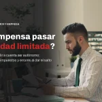 Profesional revisa documentos en su mesa de trabajo, con el titular sobre si compensa pasar de autónomo a sociedad limitada
